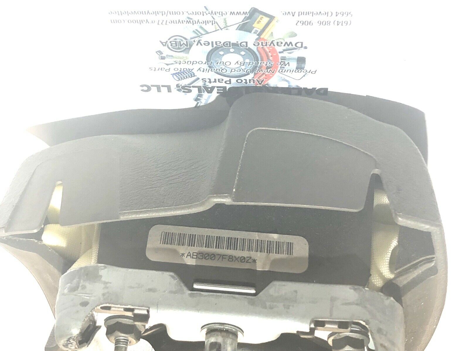 Front view of OEM black driver steering wheel airbag for 2004-2006 Cadillac Escalade with textured cover, Cadillac crest emblem, and embossed AIRBAG text.