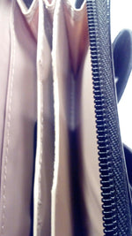 Nude zip around wallet with patent leather trim and bow.