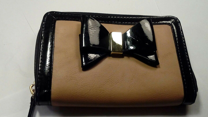 Nude zip around wallet with patent leather trim and bow.
